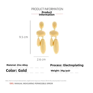 Detail view of large gold-tone geometric alloy earrings with sizing and material specs