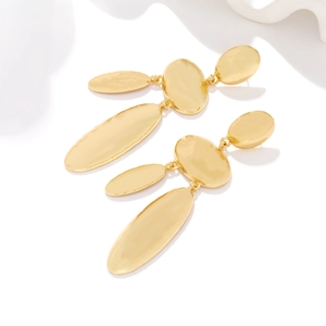 Macro view of gold geometric drop earrings with triple oval links and textured finish