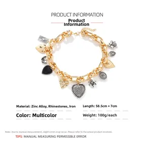 Detail view of heart and flower charms on a gold chain necklace with 58.5cm length