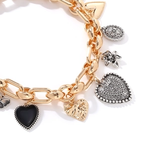 Vintage gold link necklace with heart, flower, and beetle pendants in mixed metal design