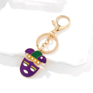 Carnival mask keychain with purple and green enamel plating and pearls on white stone