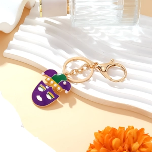 Colorful Mardi Gras clown mask keychain with purple green and yellow enamel on stone base