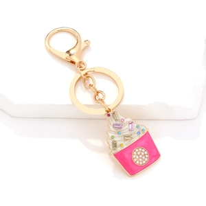 Cute enamel cupcake keychain with colorful crystals and pearls on a stone display