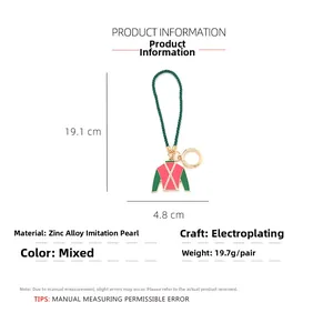Detailed view of enamel jockey shirt keychain with pearl accents and green woven rope