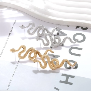 Orecchini a serpente testurizzati in oro e argento con piccoli cristalli incastonati