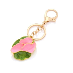 Pink floral enamel pendant keychain with gold-plated ring and lobster clasp on white surface