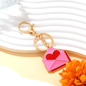 Goldener Schlüsselanhänger mit rosa Emaille-Umschlag und rotem Herzanhänger