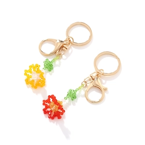 Detailed close-up of handmade beaded carnation keychains in vibrant yellow and red colors