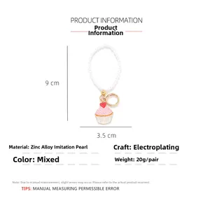 Detail view of pink enamel cupcake keychain with white faux pearls and heart charm