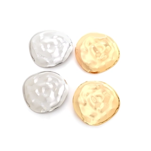 Detailed view of irregular hammered metal earrings in gold and silver finishes