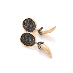 Detailed close-up of bohemian horn earrings with black rhinestones and gold plating