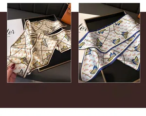 Detailed pattern of silk scarf with gold chains and colorful butterfly prints on fabric