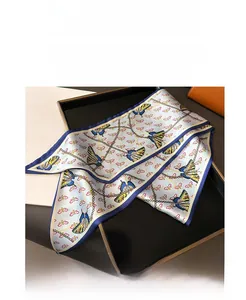 Detail of silk-like ribbon scarf with butterfly prints and golden chain patterns
