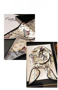 Detail of elegant butterfly silk scarf with gold chains and black contrast border
