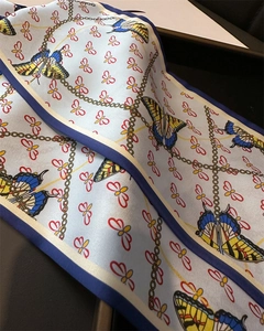 Close-up of faux silk skinny scarf featuring golden chain and butterfly print details