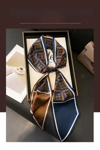 Detail of geometric two-tone twilly silk scarf presented in a luxury gift box packaging