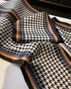 Detail of silk-like scarf with houndstooth pattern and elegant H letter motif