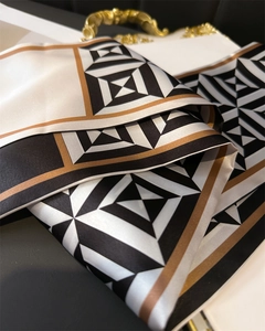 Detail of geometric pattern silk scarf with black, white, and bronze color blocking
