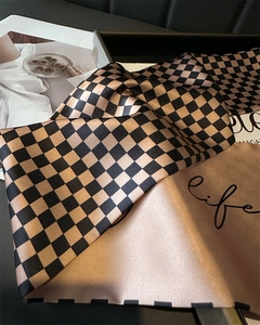 Detail of silk scarf with houndstooth pattern and elegant champagne satin finish