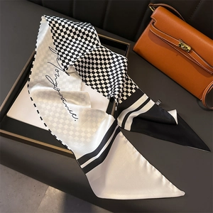 Elegant houndstooth silk scarf with handwritten text displayed on a black tray