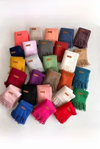 Detailed flat lay of soft scarves collection with classic fringes and leather labels