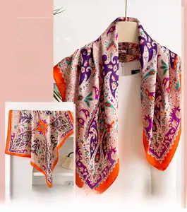 Detail of silk-like scarf featuring vibrant purple and orange paisley patterns and smooth texture