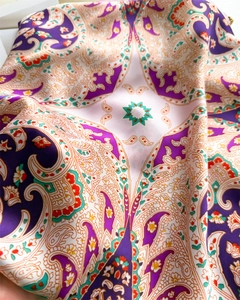 Macro shot of vintage paisley pattern silk scarf with rich purple and orange floral details
