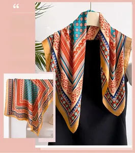 Detailed pattern of vintage silk scarf with orange blue floral motifs and geometric borders