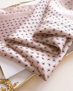 Detail of silk-like satin square scarf with paisley pattern on vintage golden tray