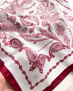 Detail eines roten Paisley-Musters auf weißem Seidenschal mit burgunderfarbenem Rand