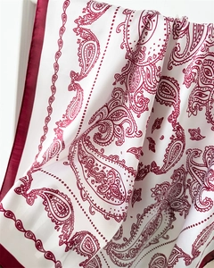 Nahaufnahme des roten Paisley-Musters auf weißem Seidenschal mit gesäumten Kanten