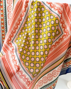 Detailed view of intricate floral and geometric patterns on silky fabric with soft folds