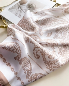 Detailansicht eines weißen Satin-Halstuchs mit braunem Paisleymuster und seidigem Glanz