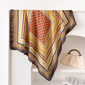 Close-up of vintage geometric floral print satin scarf styled on a white rack