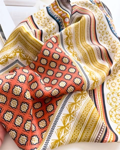 Detailed close-up of bohemian silk scarf texture with vibrant geometric and floral prints