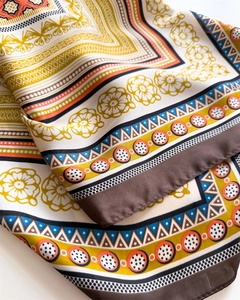 Detail shot of vintage floral silk scarf texture with geometric prints and rolled edges