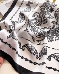 Detailaufnahme des weißen Seidengefühl-Schals mit Paisley-Muster und Kontrastrand