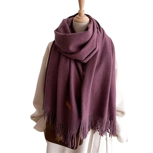 Elegant deep purple long scarf with tassels and leather patch on white coat