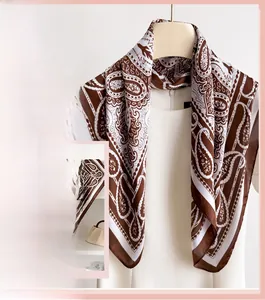 Detail of silk-like neck scarf featuring retro brown and white paisley floral patterns