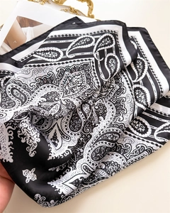 Close-up of lightweight satin scarf with monochrome paisley pattern and silky texture