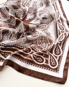 Detailed close-up of brown and ivory paisley silk-like satin square scarf with soft folds