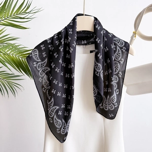 70cm black and white paisley silk scarf with bow pattern on an elegant mannequin stand