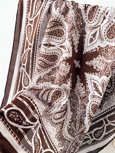 Macro shot of 70cm satin scarf featuring vintage brown and white paisley pattern texture