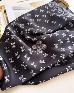 Close-up of black paisley silk-like scarf showing soft texture and elegant patterns