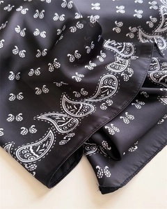 Detail of paisley print silk scarf with high-quality edge stitching on black fabric