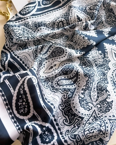 Close-up of black and white paisley silk-like scarf showing texture and glossy finish
