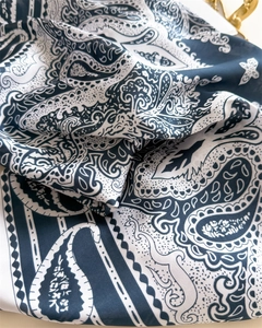 Close-up of navy blue paisley silk scarf showing smooth texture and detailed patterns