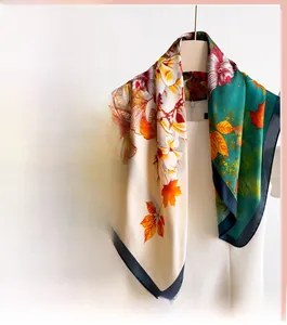 Dettaglio di sciarpa in seta con fiori rossi vivaci e motivi di foglie d'acero arancioni