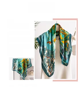 Primo piano di un foulard quadrato in raso di seta color teal con eleganti stampe floreali