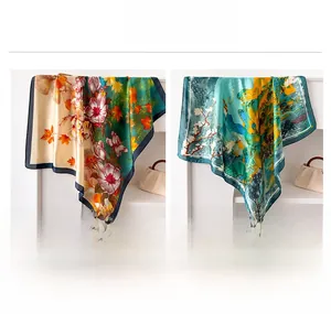 Dettaglio di foulard in seta verde smeraldo e verde menta con bordo blu scuro